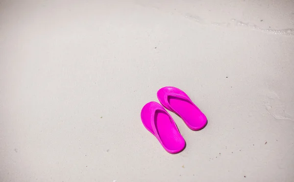 Colorful flipflop pair on sea beach — Stock Photo, Image