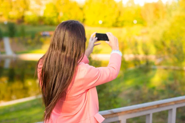 Genç kadın sonbahar günü onu telefonla bir fotoğraf almak — Stok fotoğraf