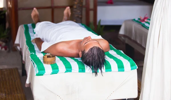 Young man getting massage lying down during summer vacation — Stock Photo, Image