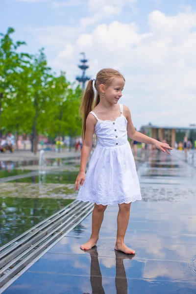 Szczęśliwa dziewczynka bawić się w odkrytym fontanna w upalny dzień — Zdjęcie stockowe