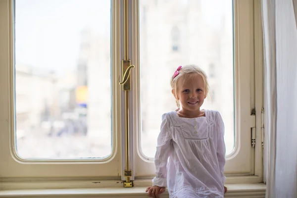 Adorable little girl looking out the window at Duomo, Milan, Italy — Stock Photo, Image