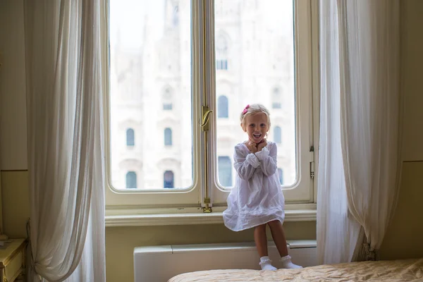 Schattig meisje keek uit het raam aan de duomo, milan, Italië — Stockfoto