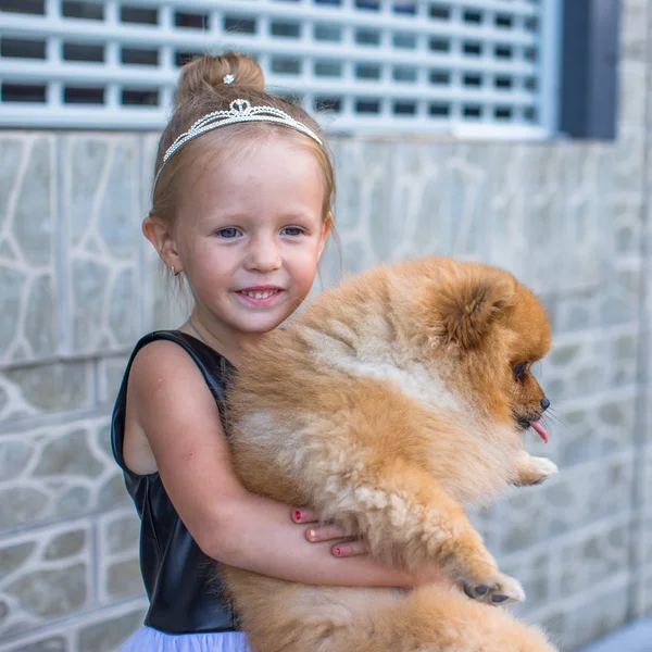 Liten blond flicka med hennes hund utomhus i parken — Stockfoto