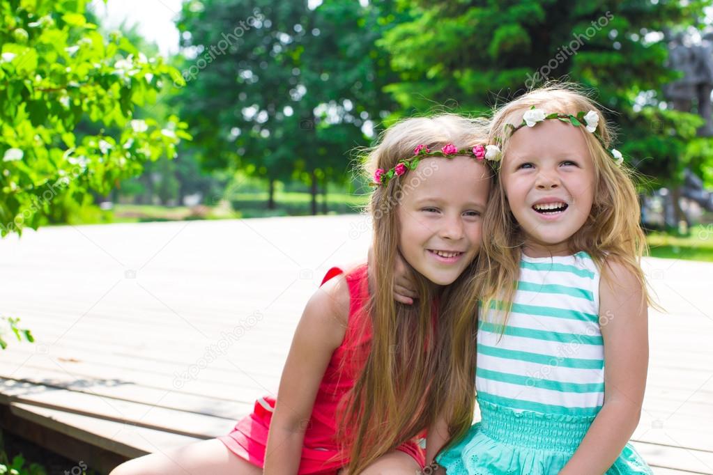 Happy adorable little girls enjoying warm summer day