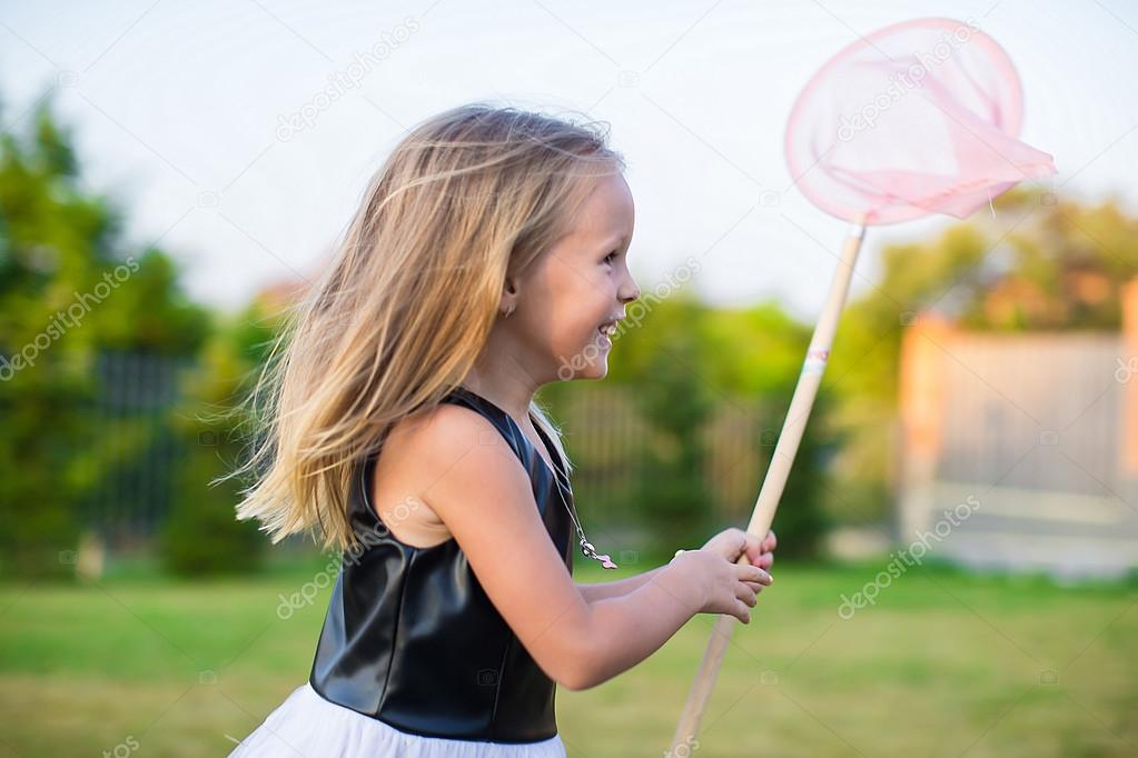 Adorable little girl catching butterflies butterfly net outdoors