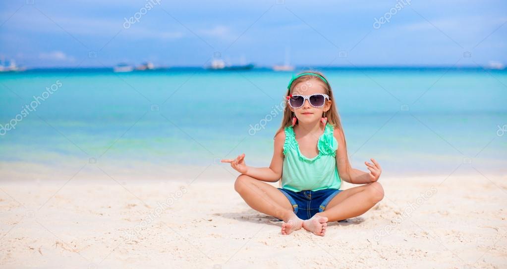 Adorable little girl having fun on white beach