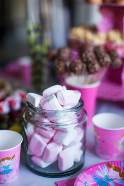 Hatmi, tatlı meringues, patlamış mısır, kremalı kek ve pasta renkli masaya açılır