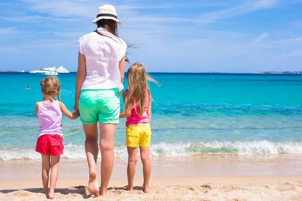 Young mom and little girls at white beach on sunny day — Stock Photo, Image