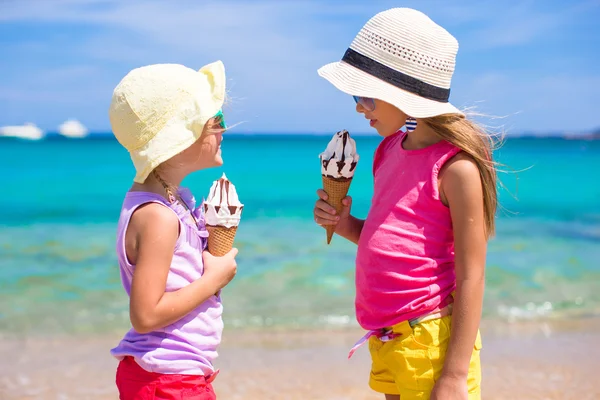 Little adorable girls eating ice cream on tropical beach — Stock Photo, Image