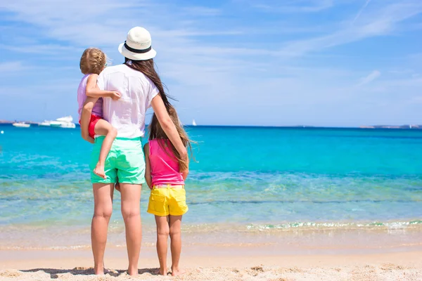 Ung mamma och små flickor på vita stranden solig dag — Stockfoto