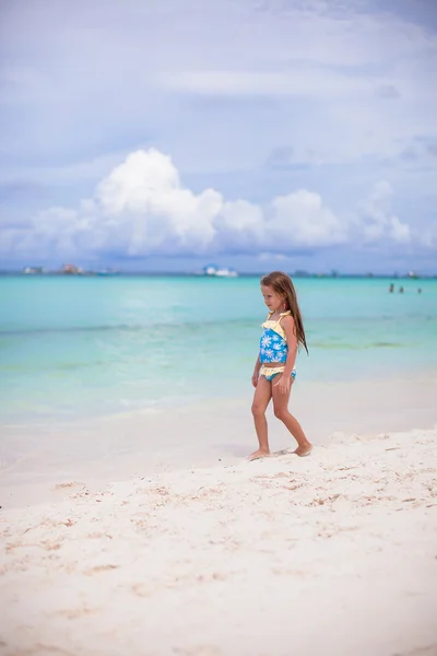 愛らしい女の子持っています楽しいです熱帯のビーチで休暇中 — ストック写真