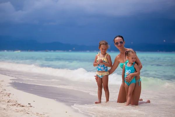 Šťastná matka a dva její děti na exotické pláži slunečného dne — Stock fotografie