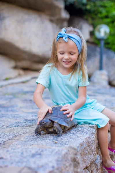 Pequeña adorable chica feliz con tortuga pequeña al aire libre —  Fotos de Stock