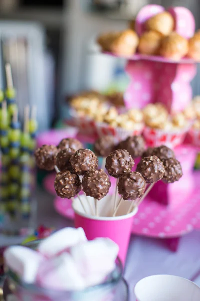 Pastelitos de chocolate en la mesa de postres de vacaciones en la fiesta de cumpleaños de los niños — Foto de Stock