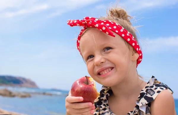 Adorable little girl have fun eating an apple — Stock Photo, Image