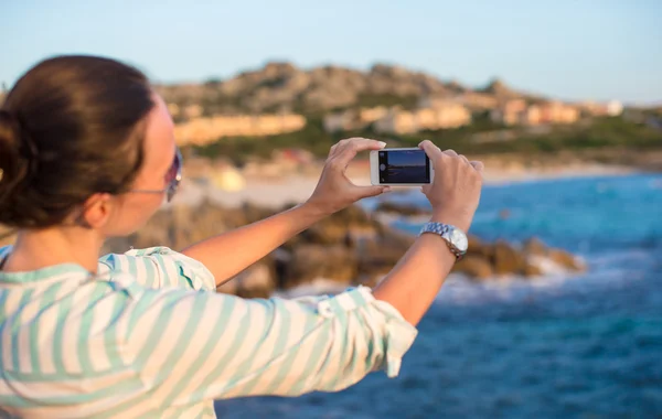 年轻女子在海滩度假期间手机拍照 — 图库照片