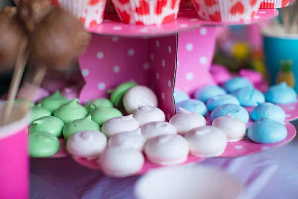 Zoete gekleurde schuimgebakjes, pops popcorn, vla gebak en cake op tafel — Stockfoto