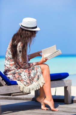 Genç kadın kitap beach tatil sırasında okuyun.