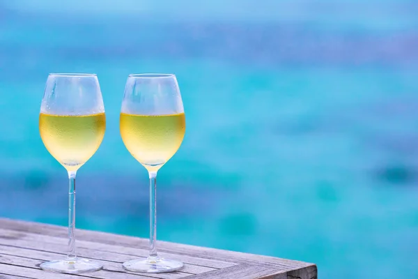 Due bicchieri di vino bianco saporito fanno da sfondo al mare — Foto Stock