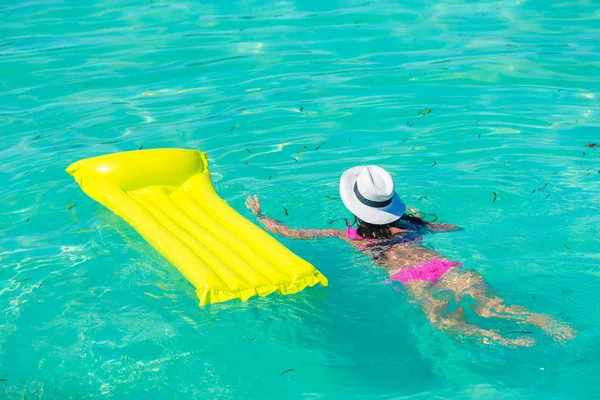 Frau entspannt sich auf aufblasbarer Luftmatratze am türkisfarbenen Wasser — Stockfoto