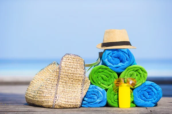 Beach and summer vacation accessories concept - close-up of colorful towels, hat, bag and sunblock — Stock Photo, Image