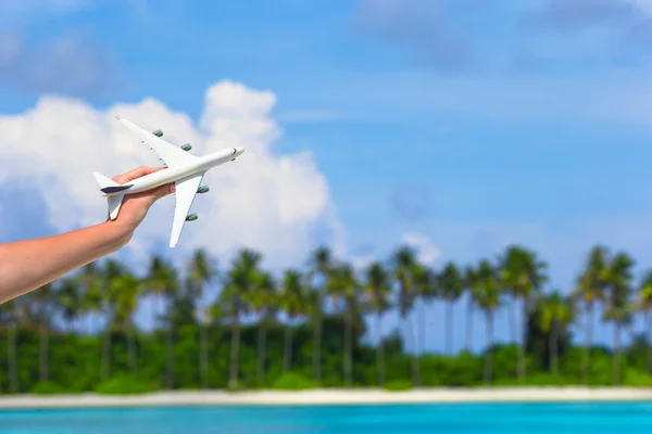 Kis fehér játék repülőgép trópusi tengerparton emberi kéz — Stock Fotó