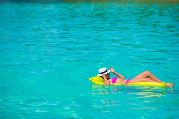 Mujer relajándose en colchón inflable del aire en agua turquesa — Foto de Stock