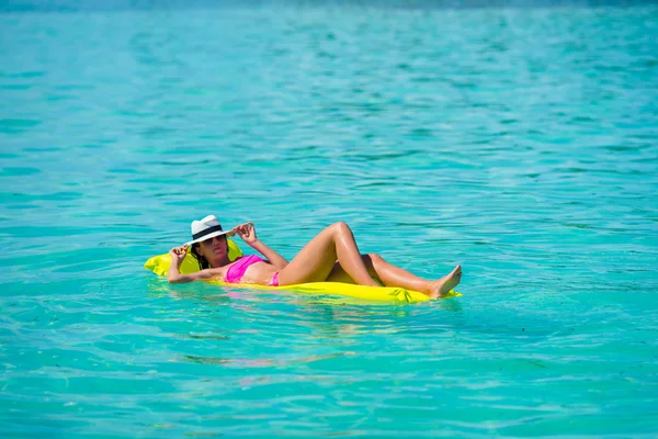 Mulher que relaxa no colchão de ar inflável na água azul-turquesa — Fotografia de Stock