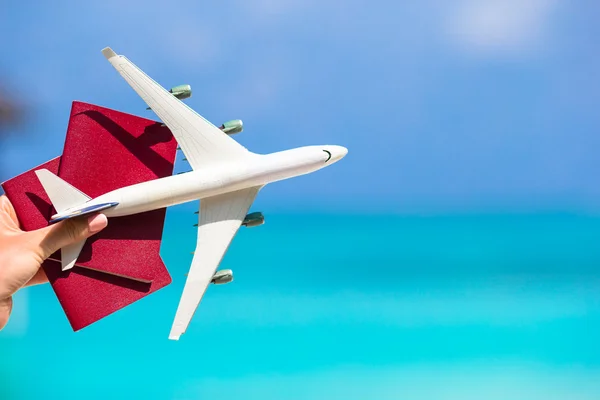 Крупный план паспортов и белый самолет фоне моря — стоковое фото