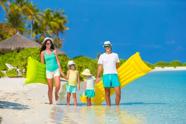 Happy beautiful family on white beach with inflatable air mattresses and toys — Stock Photo, Image