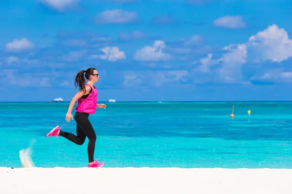 Ajuste mujer joven corriendo a lo largo de la playa tropical en su ropa deportiva — Foto de Stock
