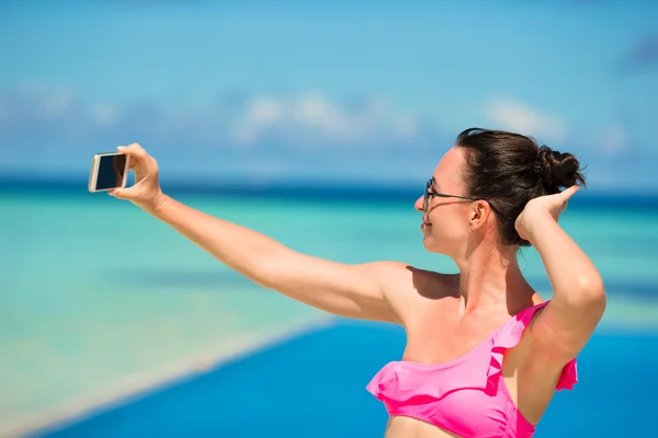 Unga vackra kvinnan äger selfie med telefon utomhus under strandsemester — Stockfoto