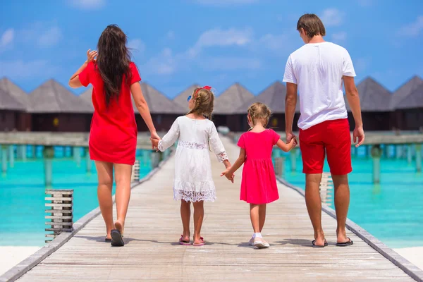 Vista posteriore di bella famiglia sul pontile di legno durante le vacanze estive al resort di lusso — Foto Stock