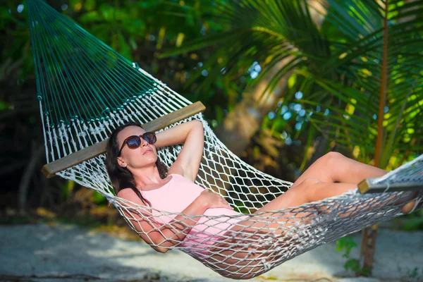 Frau im Badeanzug entspannt sich in der Hängematte beim Sonnenbaden im Urlaub — Stockfoto