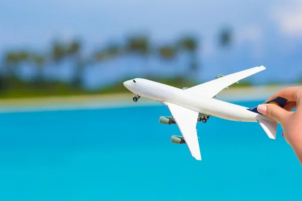 Petit avion jouet blanc sur fond de mer turquoise — Photo