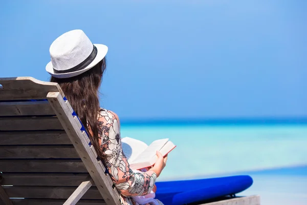 Mujer joven leyendo libro en vacaciones de verano en la playa blanca — Foto de Stock