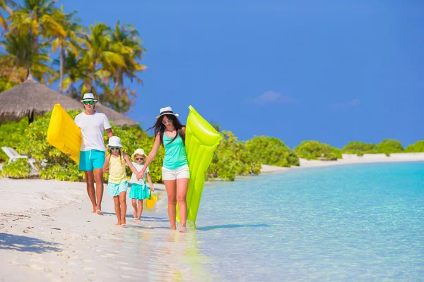 Happy beautiful family on white beach with air mattresses and kids toys — Stock Photo, Image