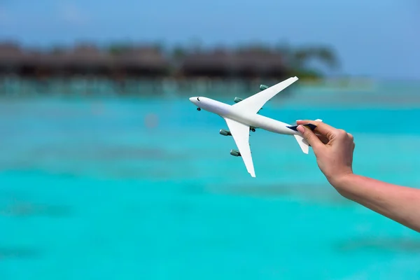 Маленький білий іграшковий літак на фоні бірюзового моря — стокове фото