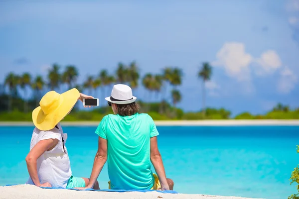 Молодая счастливая пара делает селфи с мобильным телефоном на пляже — стоковое фото