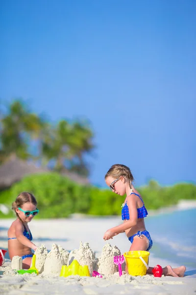 Happy little girls playing with beach toys during tropical vacation — Stock Photo, Image