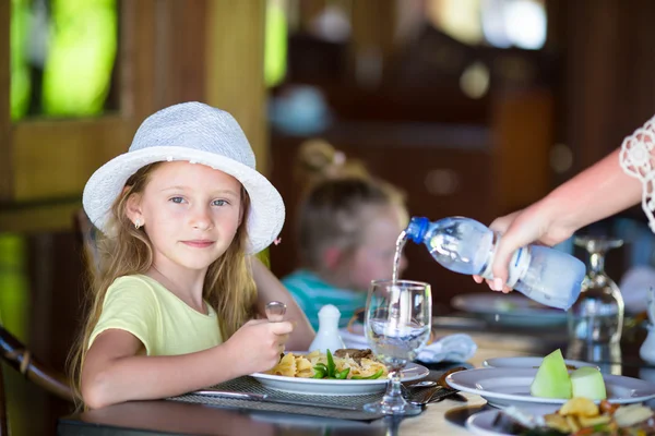 Rozkošná holčička ve venkovní restauraci na večeři — Stock fotografie