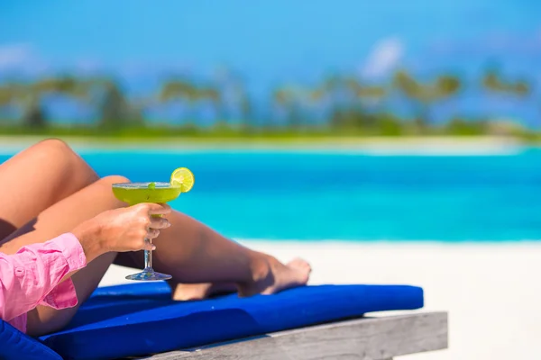 Jonge vrouw met smakelijke cocktail op wit tropisch strand — Stockfoto