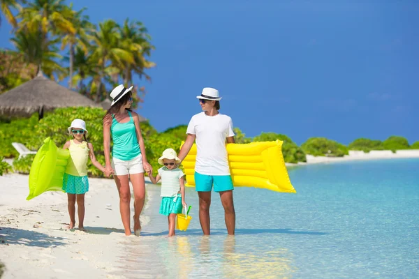 Happy beautiful family on white beach with inflatable air mattresses — Stock Photo, Image