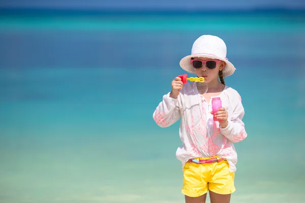 可爱的小女孩，在沙滩上吹肥皂泡泡 — 图库照片