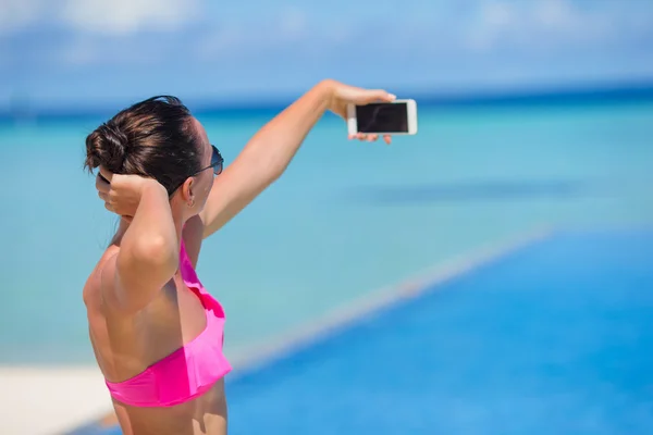 Jovem bela mulher tomando selfie com telefone ao ar livre durante as férias na praia — Fotografia de Stock