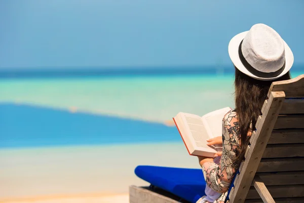 Giovane donna leggere libro vicino alla piscina — Foto Stock