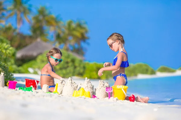 Happy little girls playing with beach toys during tropical vacation — Stock Photo, Image