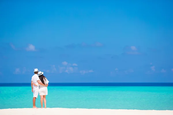 对年轻的夫妇在暑假里的白色沙滩上的后视图 — 图库照片