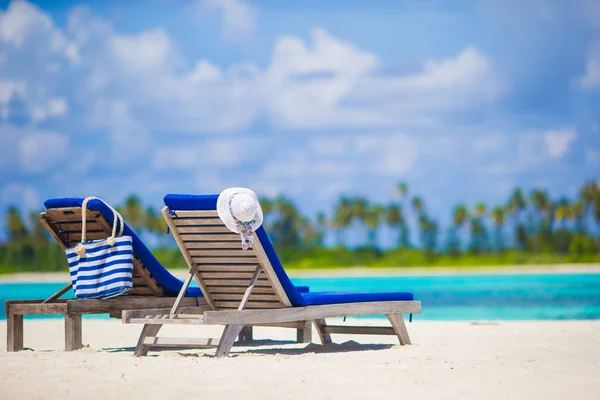 Trä lounge stolar halm hatt och väska på vita tropiska stranden på Maldiverna — Stockfoto