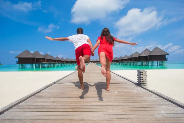 Young couple on tropical beach jetty at perfect island — Stock Photo, Image